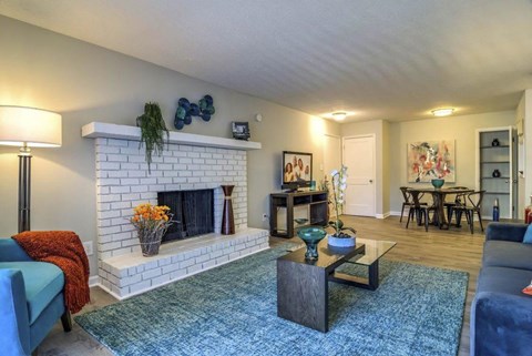 A living room with a fireplace and a blue couch at The Onyx Hoover Apartments, Hoover, AL, 35216